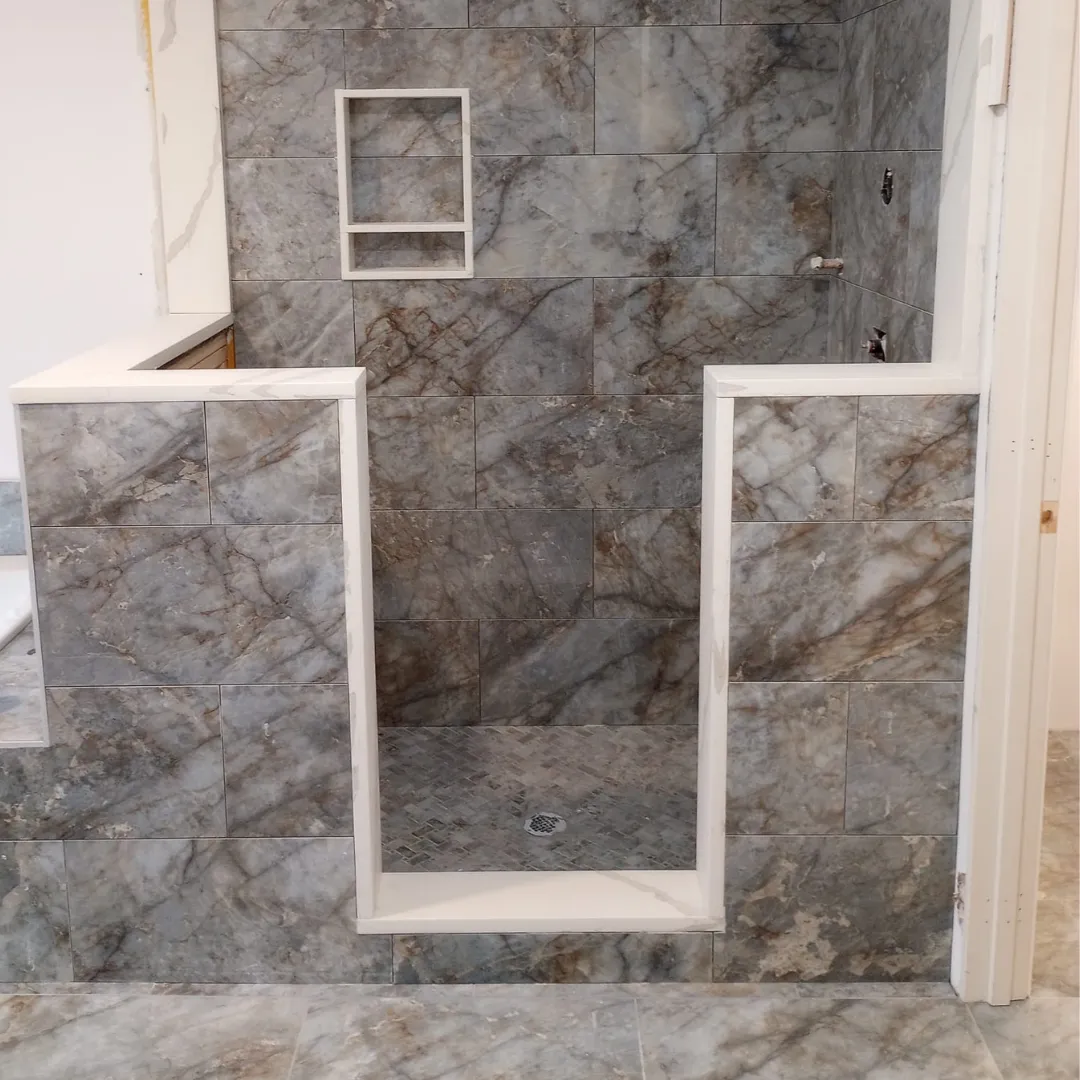 Custom walk-in shower with gray marble-look tile and double knee walls by Link Services Pro in Holden, MA