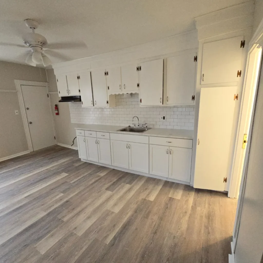 Compact white kitchen with subway backsplash and vinyl plank floor by Link Services Pro in Worcester, MA