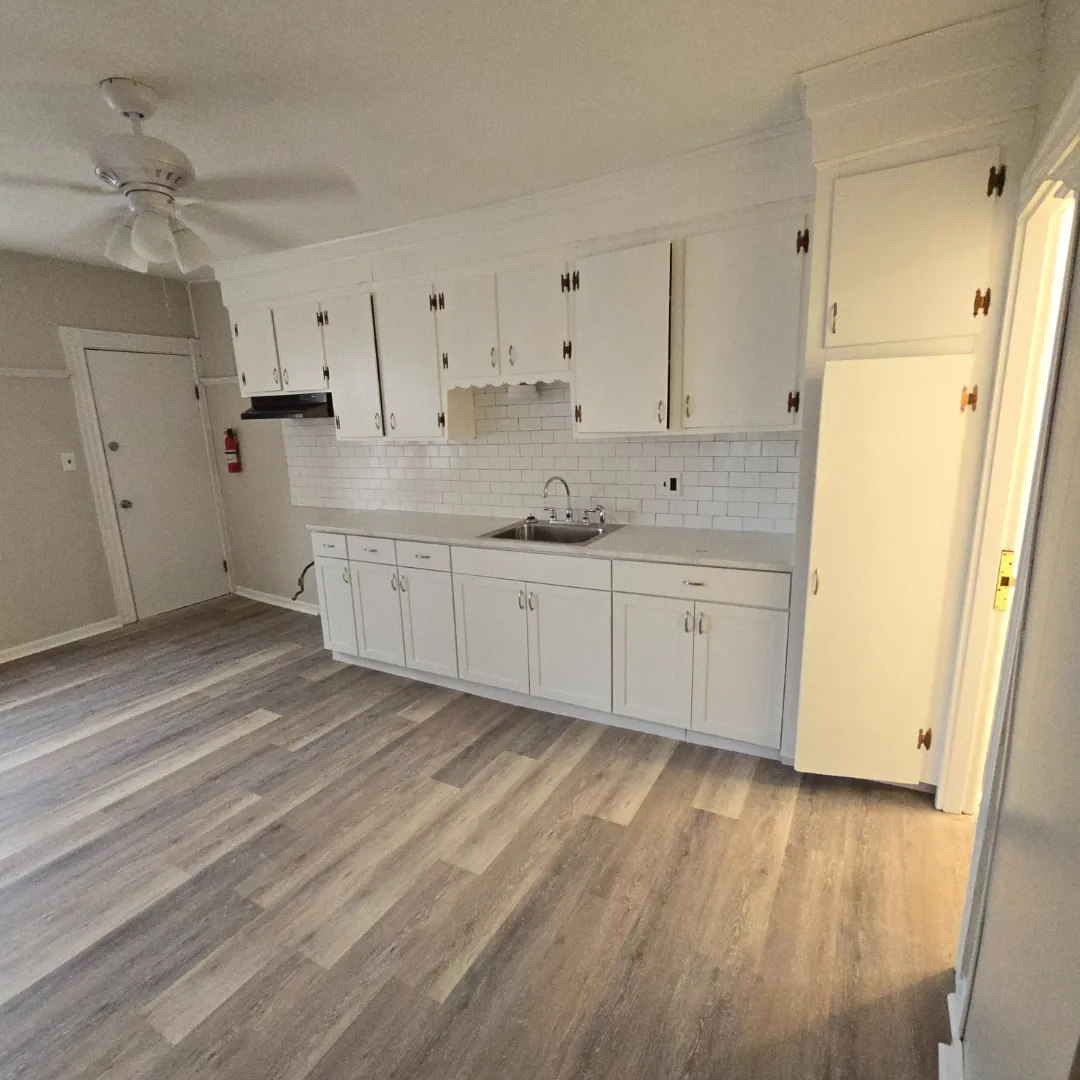 Compact white kitchen with subway backsplash and vinyl plank floor by Link Services Pro in Worcester, MA