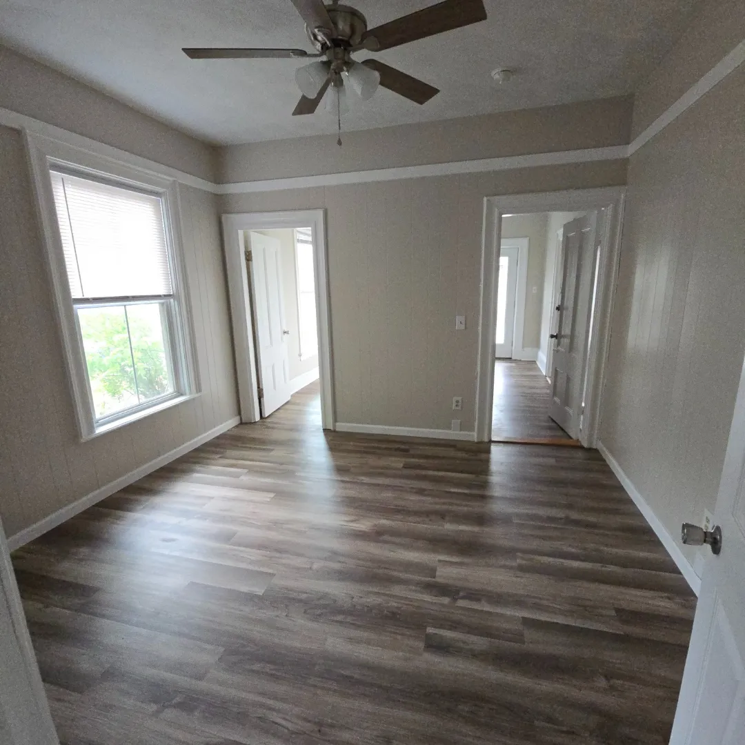 Vintage-style room with gray vinyl plank flooring and ceiling fan by Link Services Pro in Shrewsbury, MA