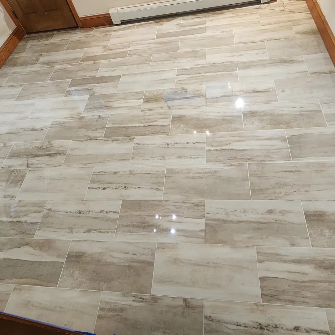 Polished travertine-look porcelain tile floor in entry hallway by Link Services Pro in Worcester, MA