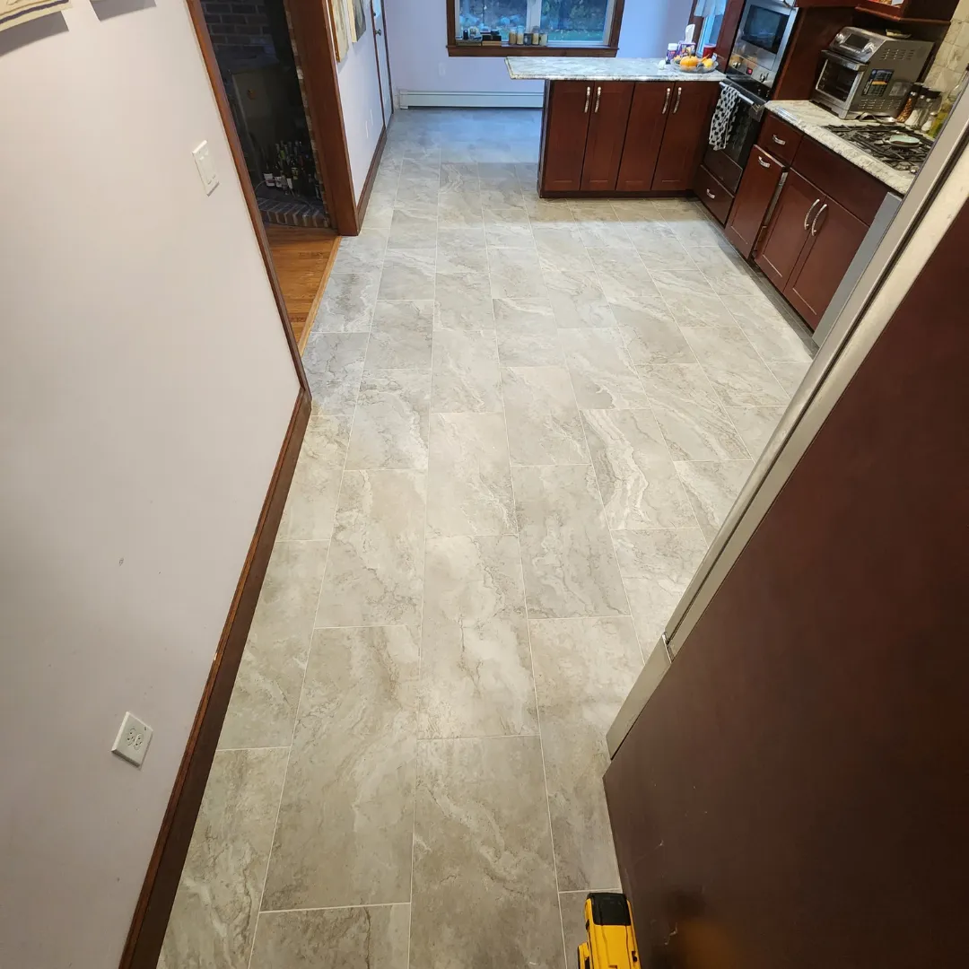 Stone-look porcelain tile flooring with cherry kitchen cabinets by Link Services Pro in Auburn, MA