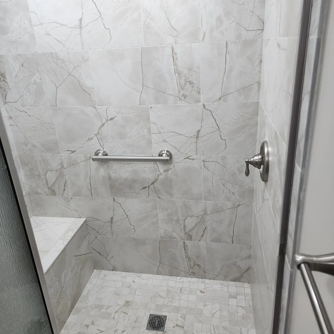 Marble-look porcelain shower with curb-free entry and mosaic floor by Link Services Pro in Worcester, MA
