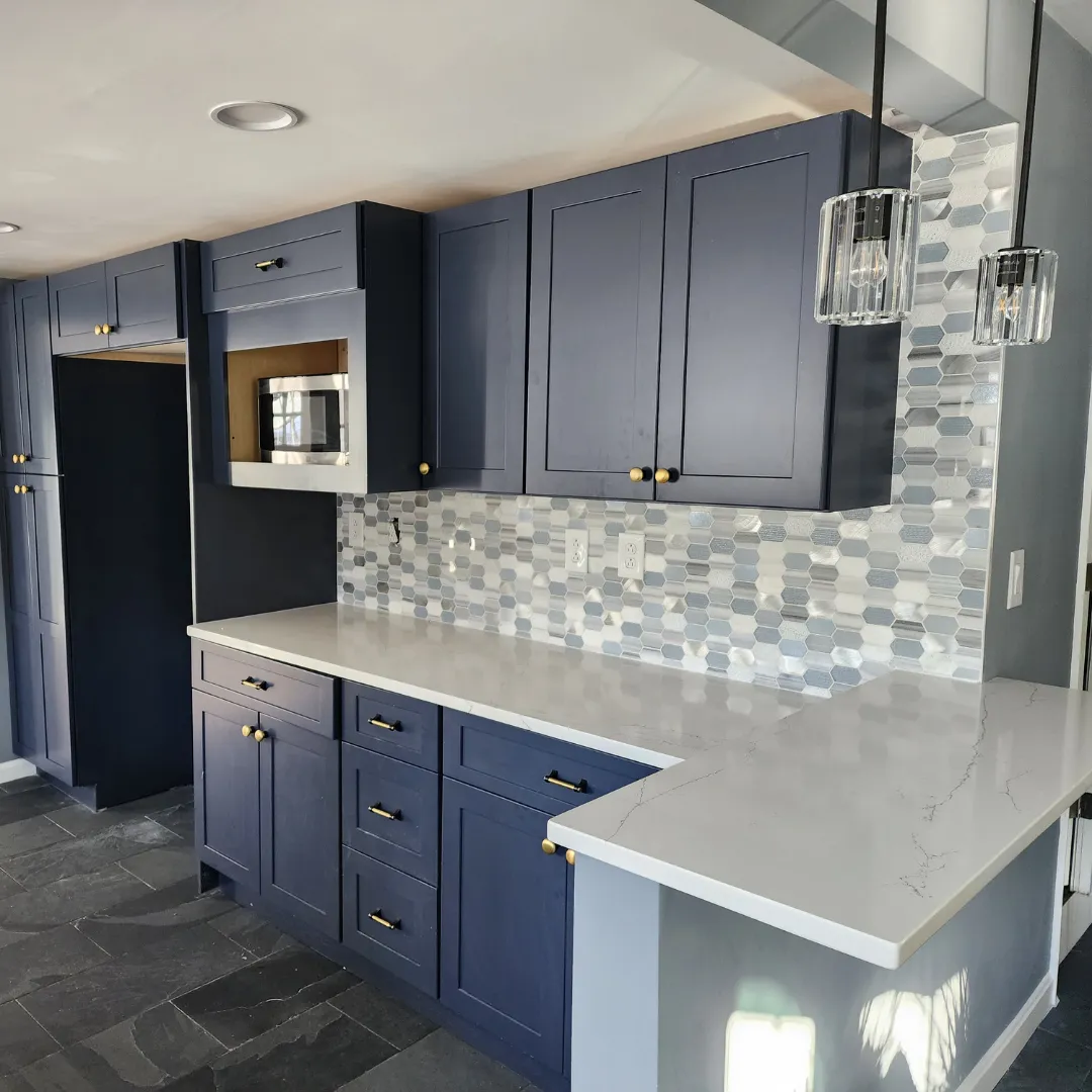 Navy blue shaker kitchen with hexagon mosaic backsplash and quartz counters by Link Services Pro in Shrewsbury, MA