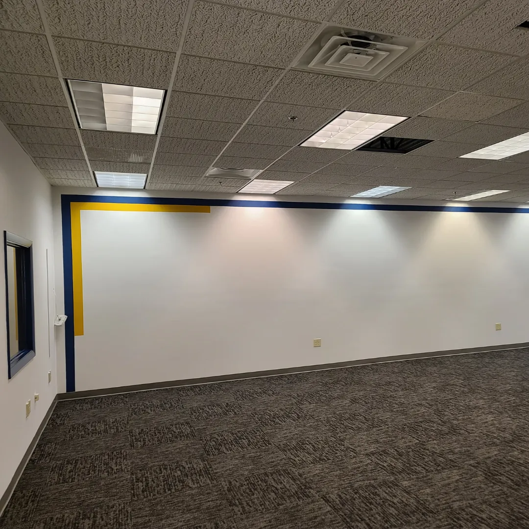 Commercial office painted white with navy and yellow accent border on carpet by Link Services Pro in Shrewsbury, MA