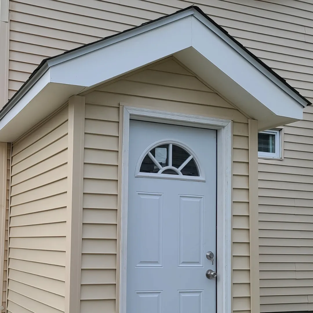 Exterior front entry with new vinyl siding, white trim and arched window door by Link Services Pro in Millbury, MA