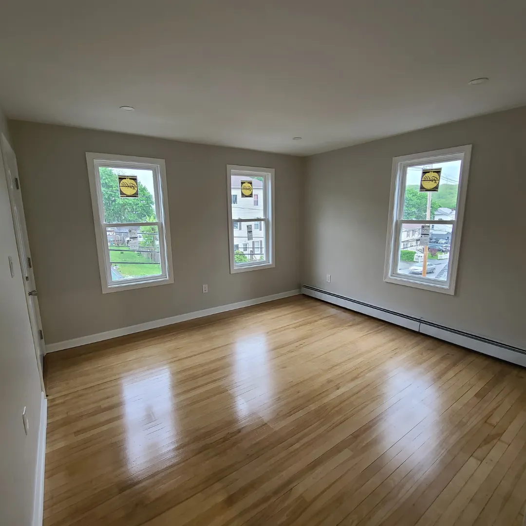 Refinished natural maple hardwood flooring in bright bedroom by Link Services Pro in Shrewsbury, MA