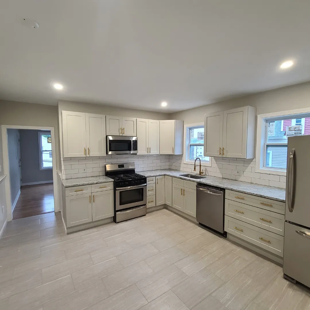 White shaker kitchen with subway tile backsplash and granite countertops by Link Services Pro in Westborough, MA