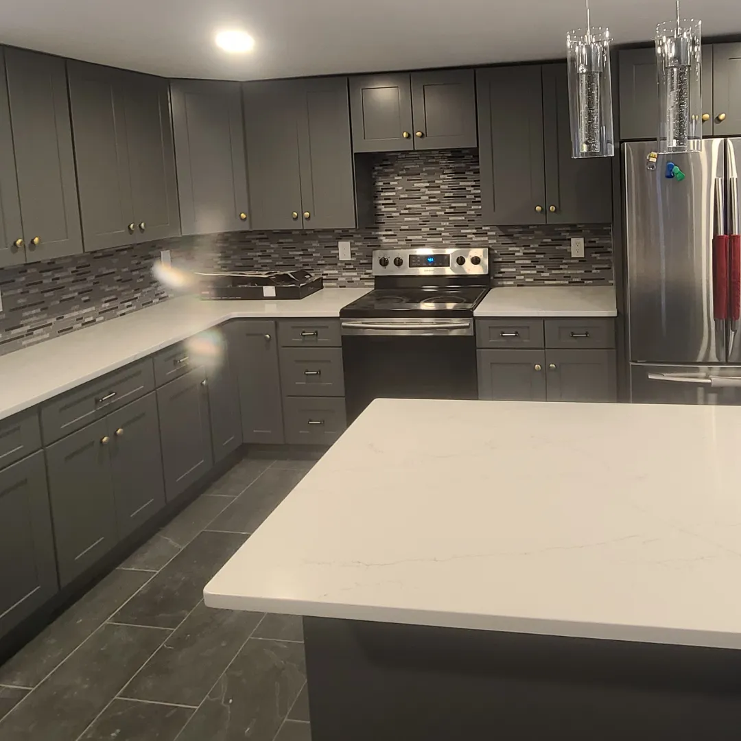 Modern gray shaker kitchen with quartz waterfall island and dark mosaic backsplash by Link Services Pro in Shrewsbury, MA